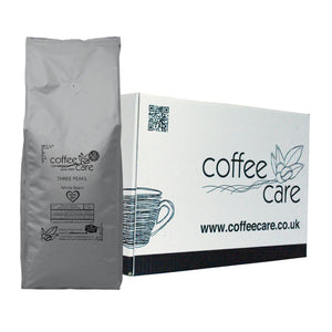 one white Coffee Care box with a grey recyclable kilo packet of Coffee Care's Three Peaks Beans lent up next to it. 100% arabica coffee, Farm Shop and Deli Show 2023 Gold Product Award and Deliciously Yorkshire Best Beverage Winner