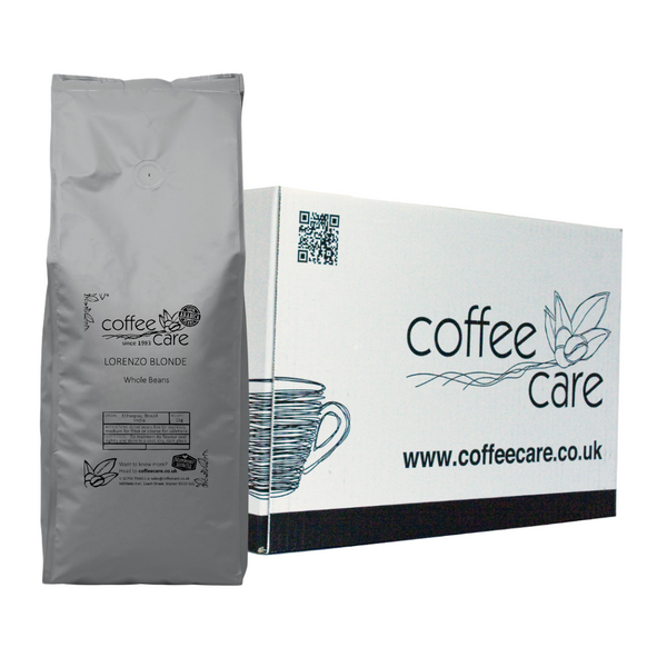 one white Coffee Care box with a grey recyclable kilo packet of Coffee Care's Lorenzo Blonde beans lent up next to it. 100% arabica coffee.