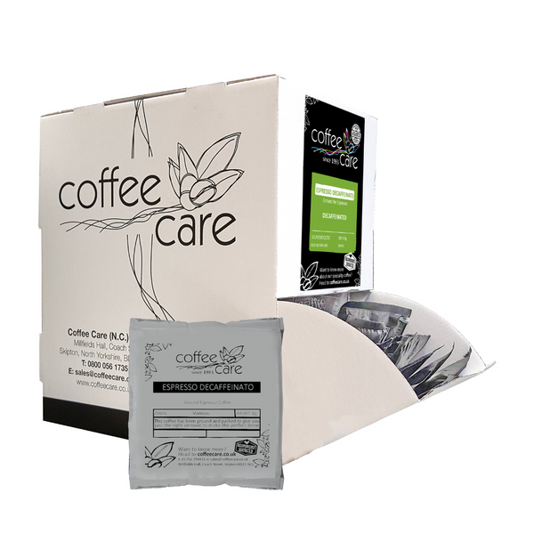 Coffee Care dispenser box of 100 grey recyclable packets of 8g Espresso Decaffeinato ground for espresso coffee. A white dispenser box with 1 sachet lent up next to it.