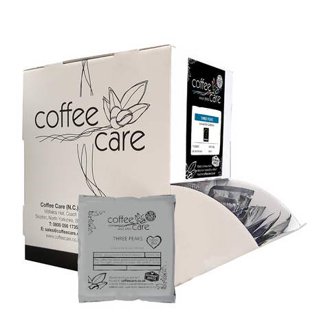 A Coffee Care dispenser box of 100 grey recyclable packets of 20g Three Peaks Blend cafetiere coffee. A white dispenser box with 1 cafetiere sachet lent up next to it.