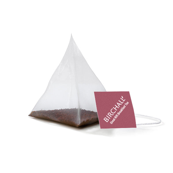 A single prism deep red tagged tea bag of Birchall Great Rift Tea. Mesh tea bag with small loose leaf inside.