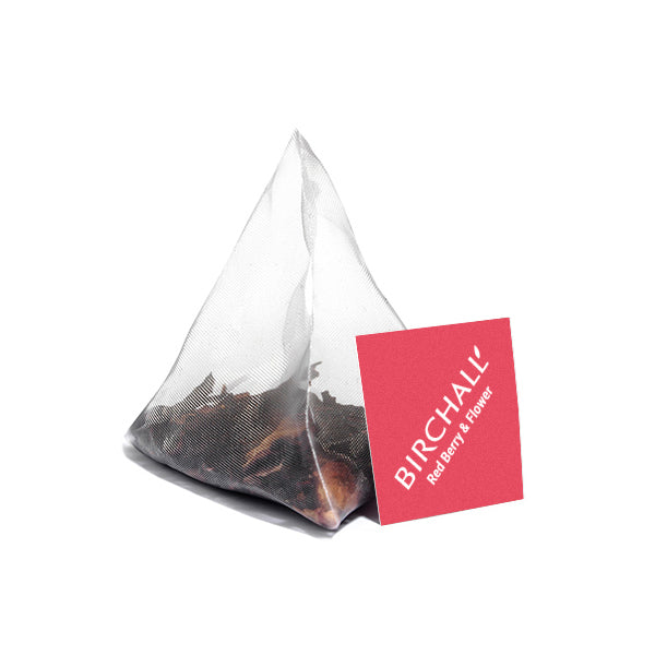 A single plant based prism teabag of Birchalls Red Berry and Flower Tea